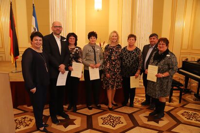 Ministerpräsidentin Manuela Schwesig (r.) und Bildungsministerin Birgit Hesse (l.) zeichnen Katrin Schlövogt für ihr ehrenamtliches Engagement mit der Ehrennadel des Landes Mecklenburg-Vorpommern aus.